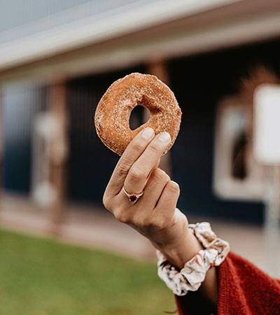 Woman holding a delicious apple cider donut from the Flamm Orchards farm store located in Cobden, IL.
