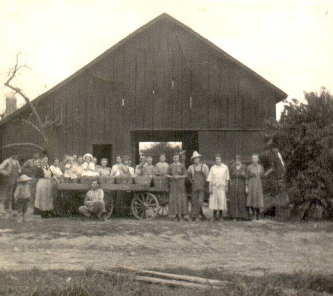 Flamm family and workers standing outside of the old packing shed at the Flamm Orchard in Cobden, IL.